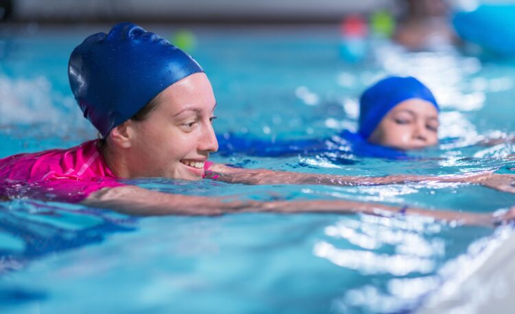Swimming lesson. Cute little boy learning to swim with swimming